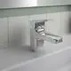 Kromfarbene Waschtischarmatur von Ideal Standard mit moderner Ausführung und eckigem Design, montiert auf einem weißen Waschbecken vor einer gefliesten Wand.